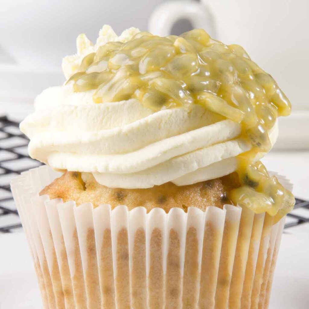 Homemade honey passion fruit blueberry cupcakes with golden tops" "Close-up of a cupcake featuring blueberries and passion fruit, sweetened with natural honey" "Freshly baked cupcakes with honey-infused batter, studded with blueberries and a hint of passion fruit" "Delicious tropical fruit cupcakes made with pure honey" "Moist and flavorful honey passion fruit blueberry cupcakes ready to serve"