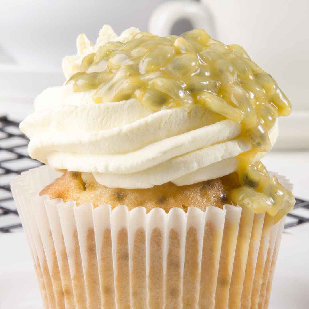 Homemade honey passion fruit blueberry cupcakes with golden tops" "Close-up of a cupcake featuring blueberries and passion fruit, sweetened with natural honey" "Freshly baked cupcakes with honey-infused batter, studded with blueberries and a hint of passion fruit" "Delicious tropical fruit cupcakes made with pure honey" "Moist and flavorful honey passion fruit blueberry cupcakes ready to serve"