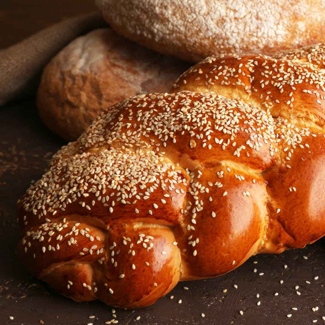 Homemade honey whole wheat challah bread Traditional braided whole wheat challah with honey glaze Freshly baked honey-sweetened whole wheat challah Golden brown whole wheat challah loaf made with honey Delicious whole wheat challah bread featuring natural honey